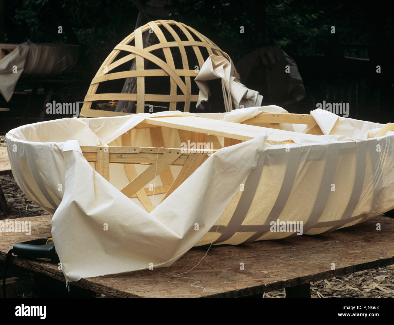 CORACLE machen Baumwolle Kattun Kursmaterial ist gestreckt und um Ash Holzrahmen des Bootes gefaltet dann geheftet Stockfoto