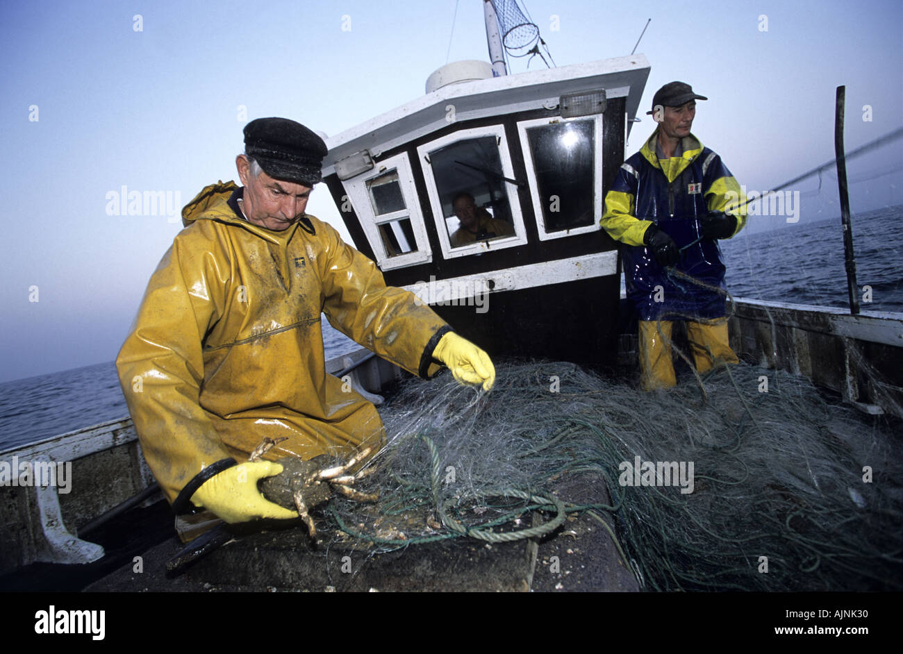 Krabben-Fischer entfernen von Treibnetzen, Hastings, England Stockfoto