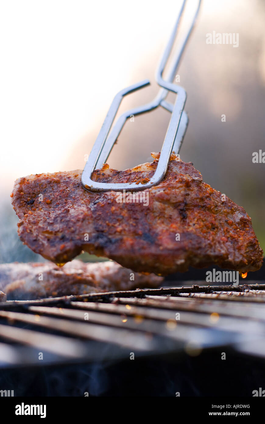 Delicious chuck Steak auf dem Grill in Metall Zange geringe Schärfentiefe Stockfoto