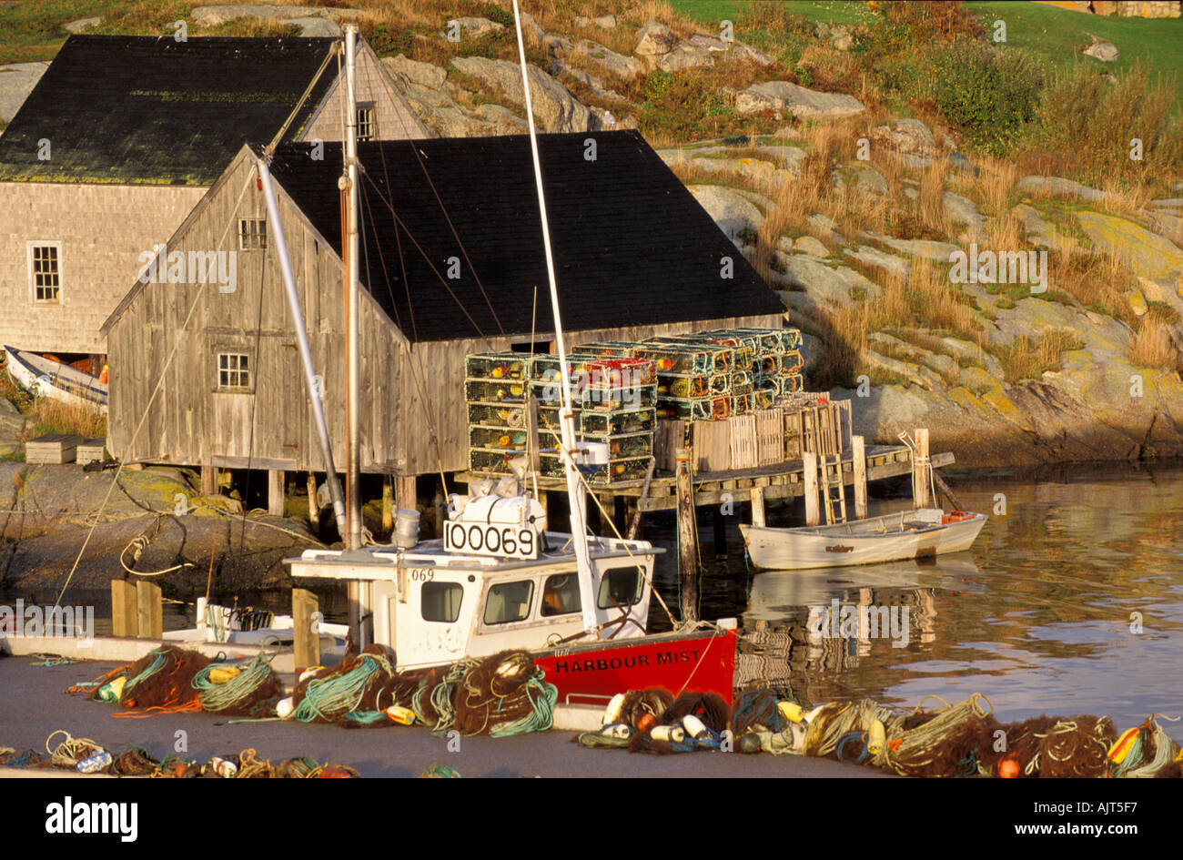 Kanada Nova Scotia Dorf von Peggys Cove bunte Fischerei Fischernetze und Hummerfallen gegen Fischhaus gestapelt Stockfoto
