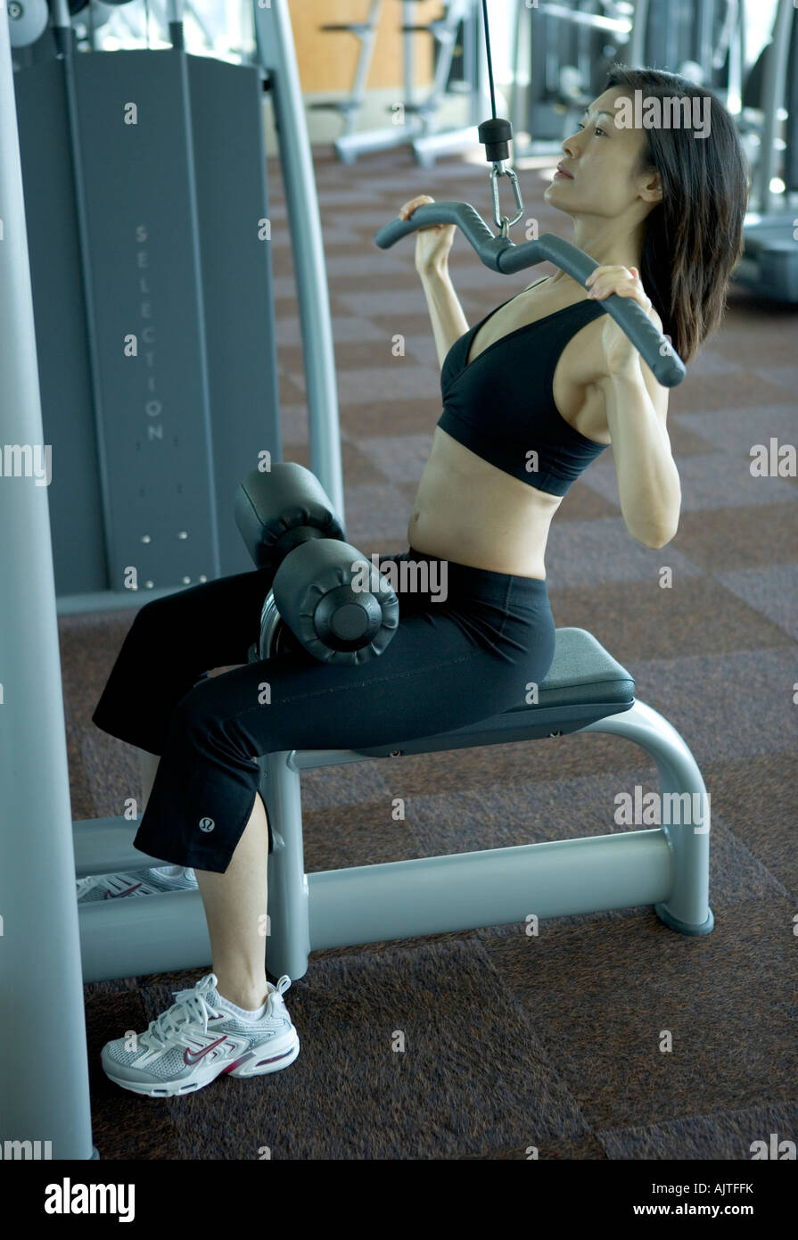 Seitenansicht einer Mitte Erwachsene Frau mit einer seitlichen Pulldown-Maschine Stockfoto