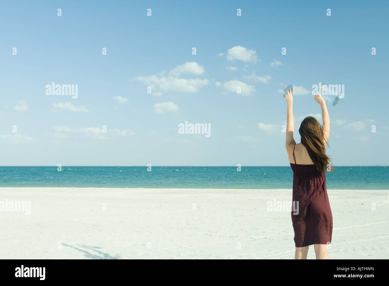Frau am Strand stehen, hält klare Container, Rückansicht Stockfoto