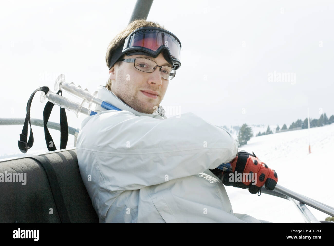 Junge männliche Skifahrer unter Skilift Stockfoto