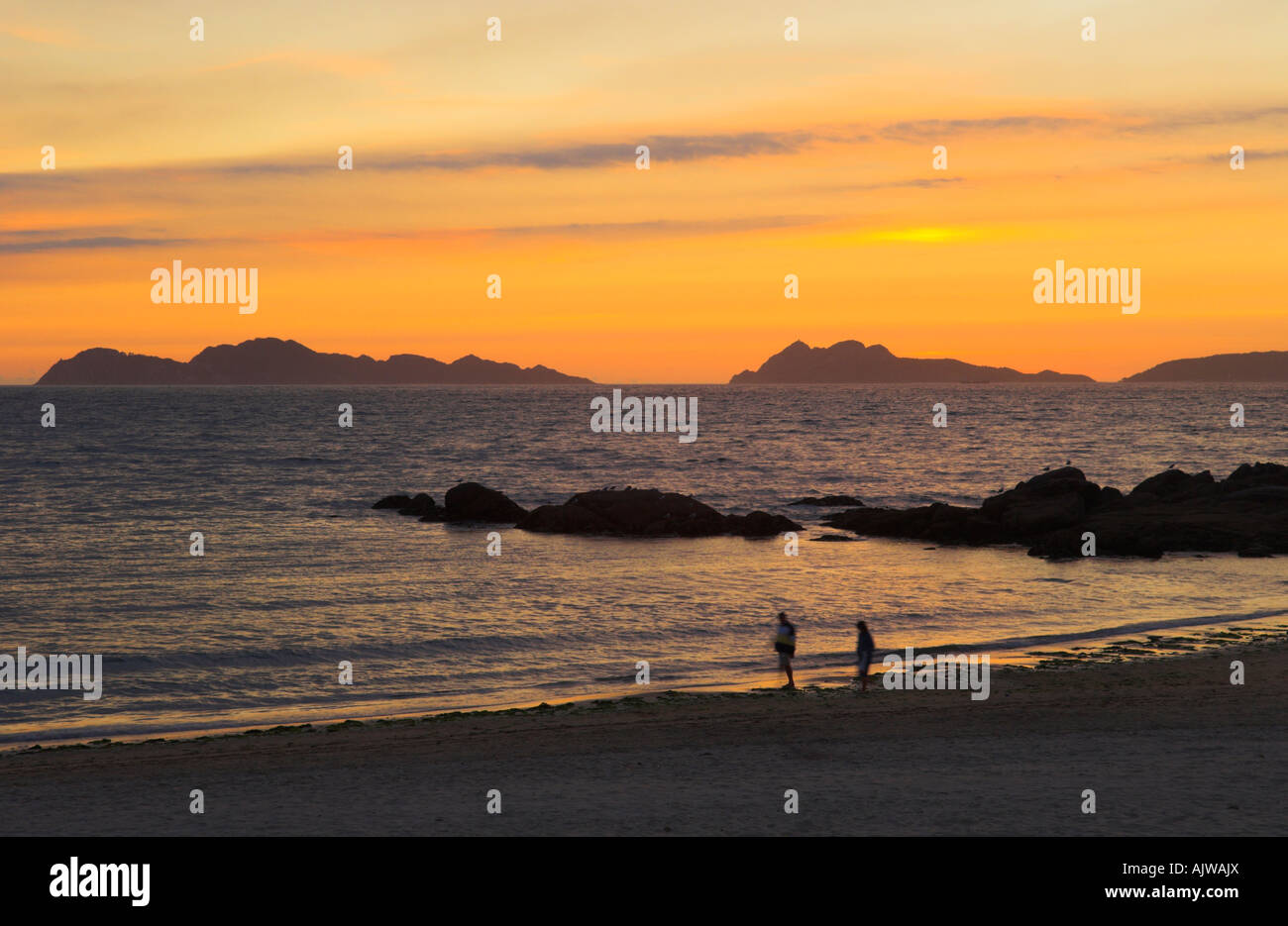 Wanderer auf galizische Playa de Samil Beach bei Sonnenuntergang Cies-Insel im Hintergrund Spanien Stockfoto