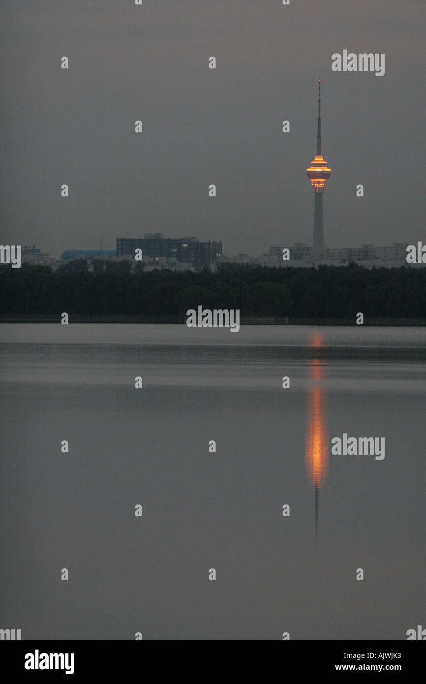 Lichter auf dem China Central TV-Turm in Peking reflektieren in einem See im Sommerpalast. Stockfoto