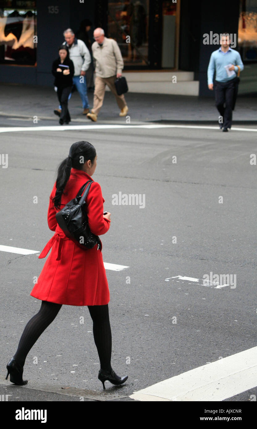 Eine asiatische Frau überquert eine Straße in Sydney Stockfoto