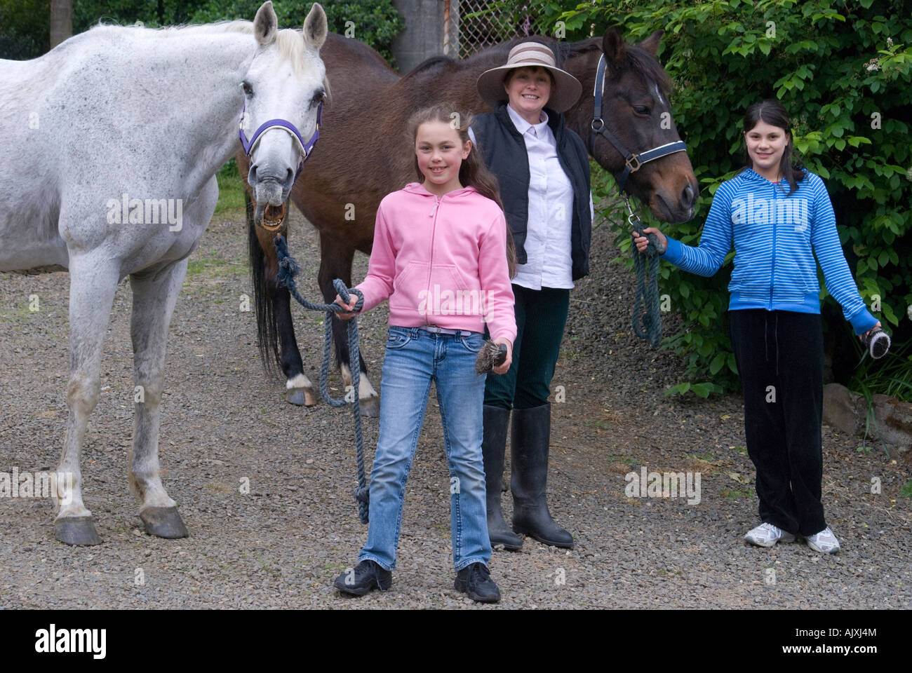 Zwei junge Mädchen und Frau mit zwei Pferden Stockfoto