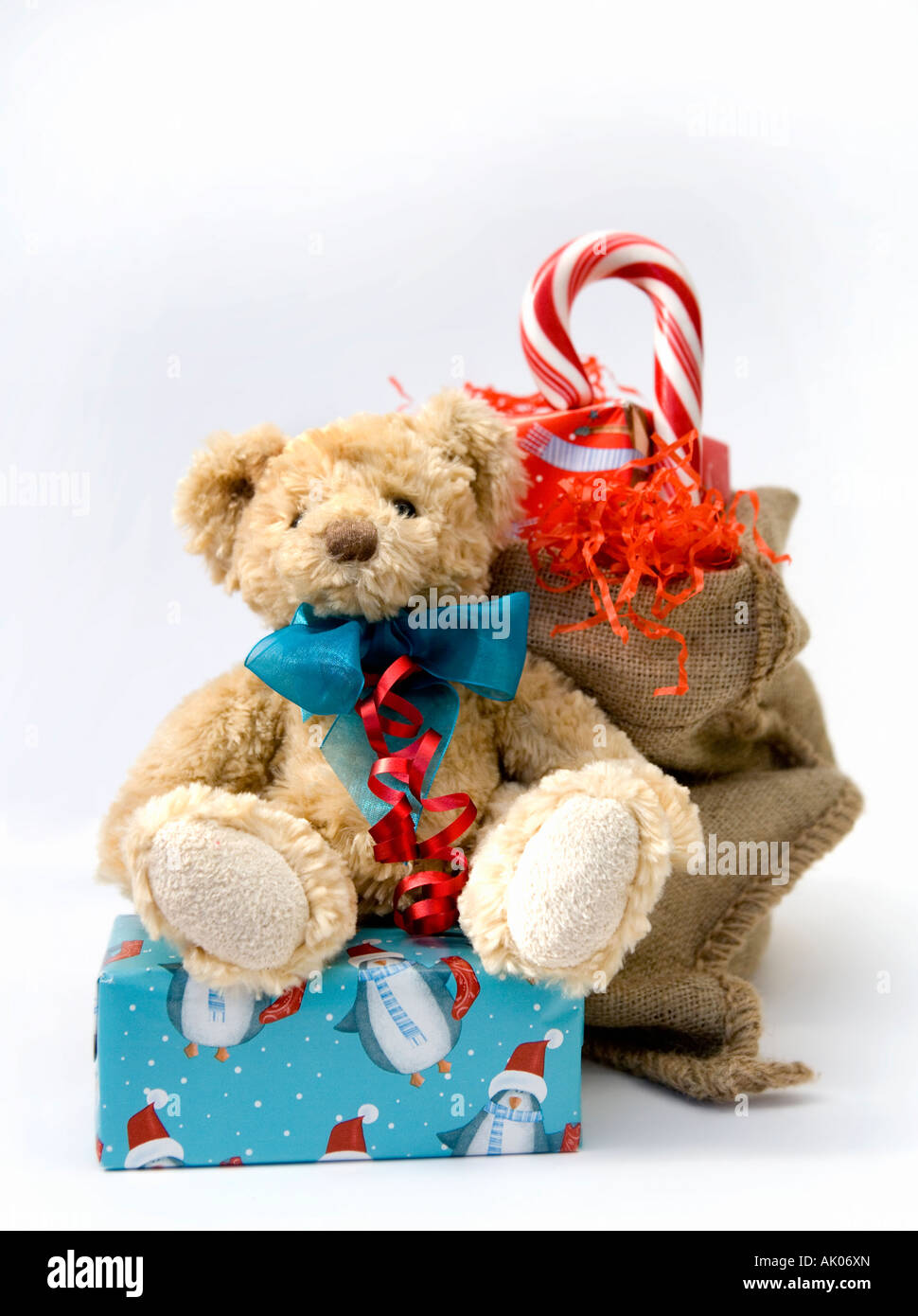 Teddy Bär sitzend auf einem Weihnachten präsentieren eine Zuckerstange und Santa es sack Stockfoto
