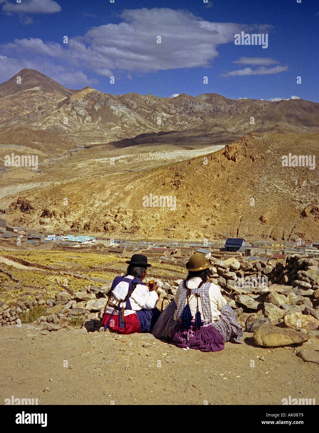 Paar Freunde indigene Frauen in traditioneller Kleidung sitzen am Rand der Klippe von Minen Potosí Bolivien Südamerika Latein Stockfoto