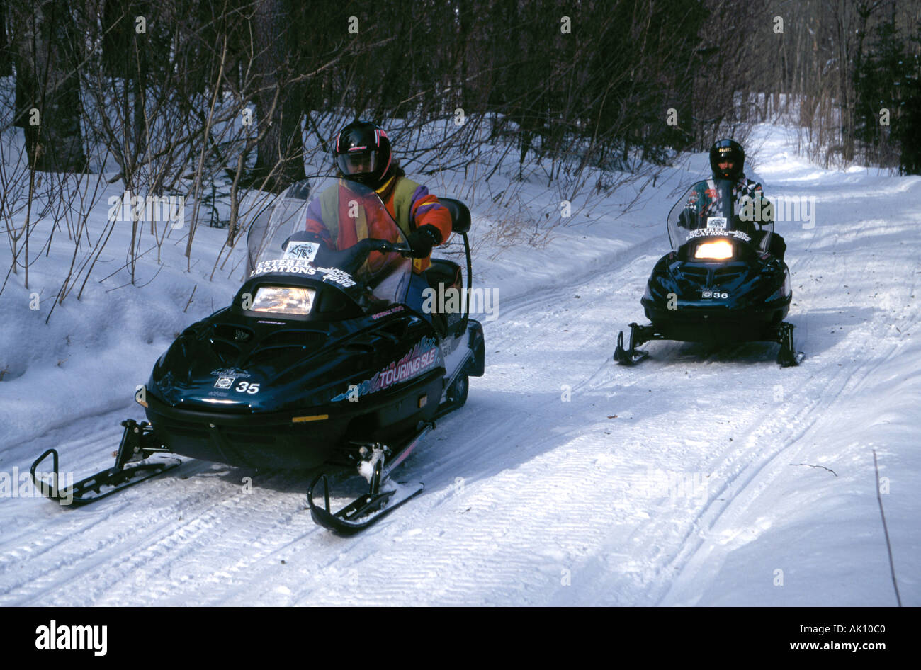 Snowmobil-Fahrer fahren durch Waldwege in Quebec, Kanada, Stockfoto