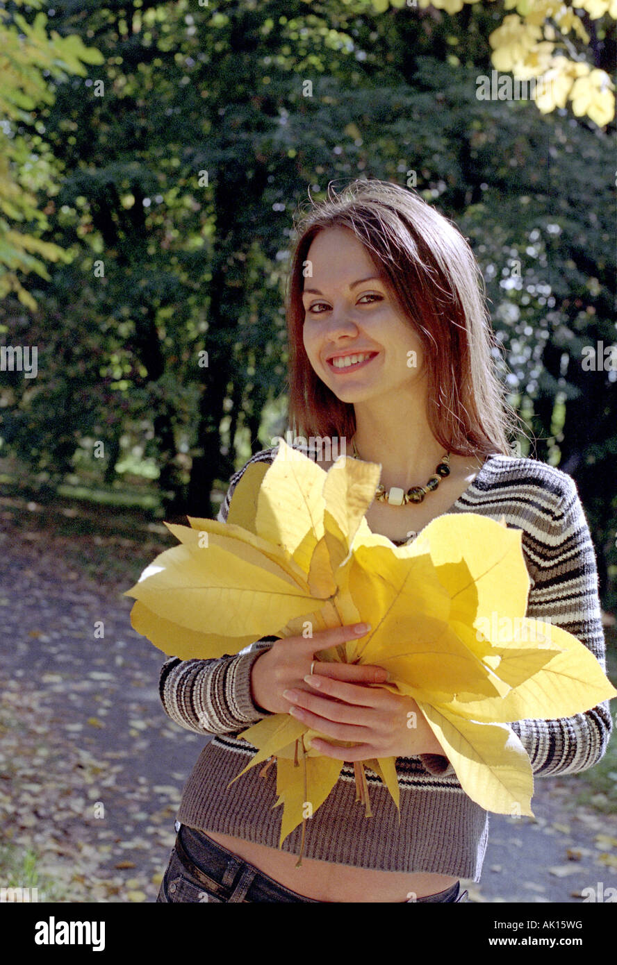 junge Frau mit Bouquet von gelben Blätter Stockfoto