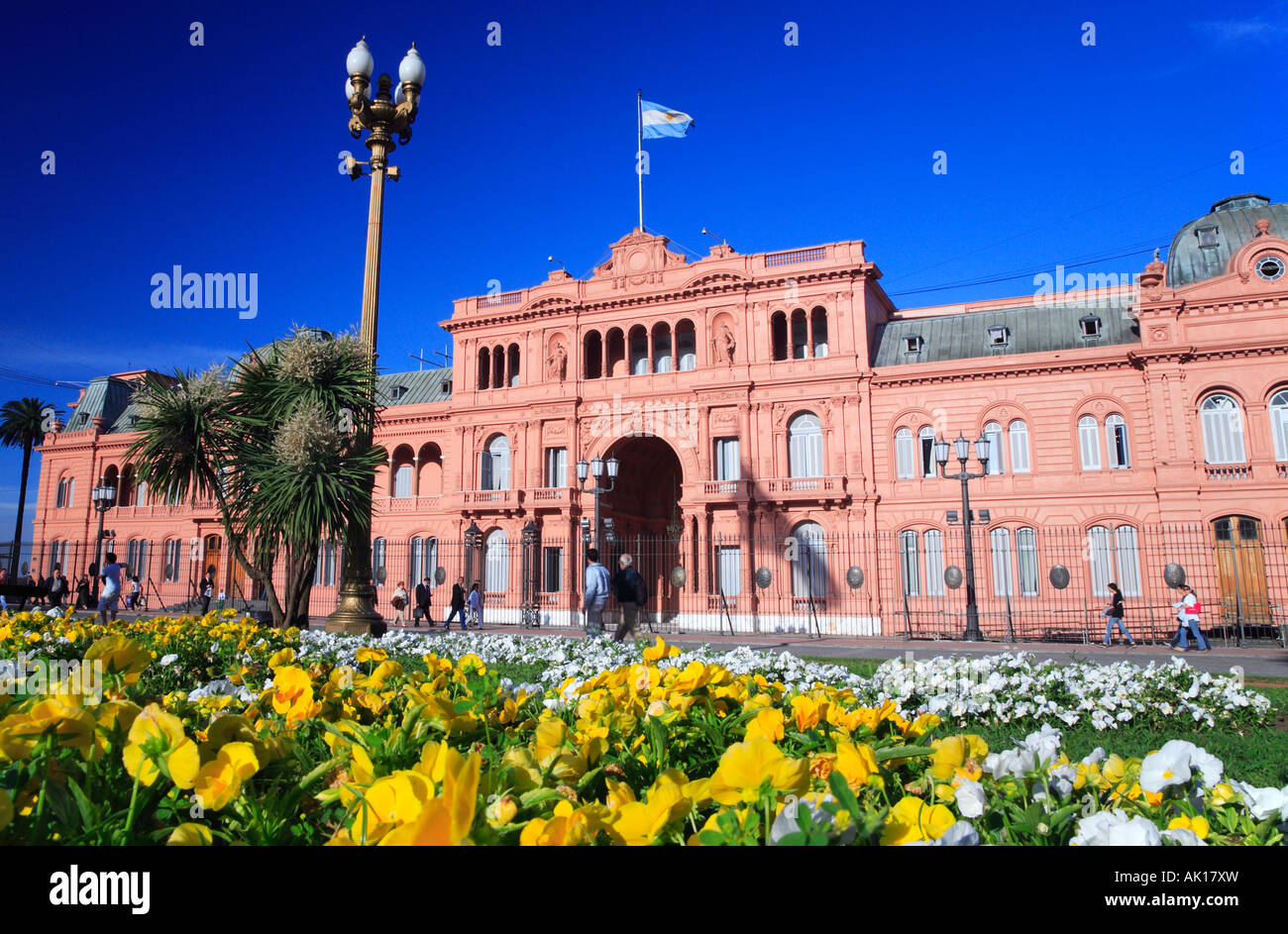 "Rosa Haus" (nationale Regierung Präsidentenpalast) mit Menschen und weiß / gelbe Blüten. Plaza de Mayo, Buenos Aires, Arg Stockfoto
