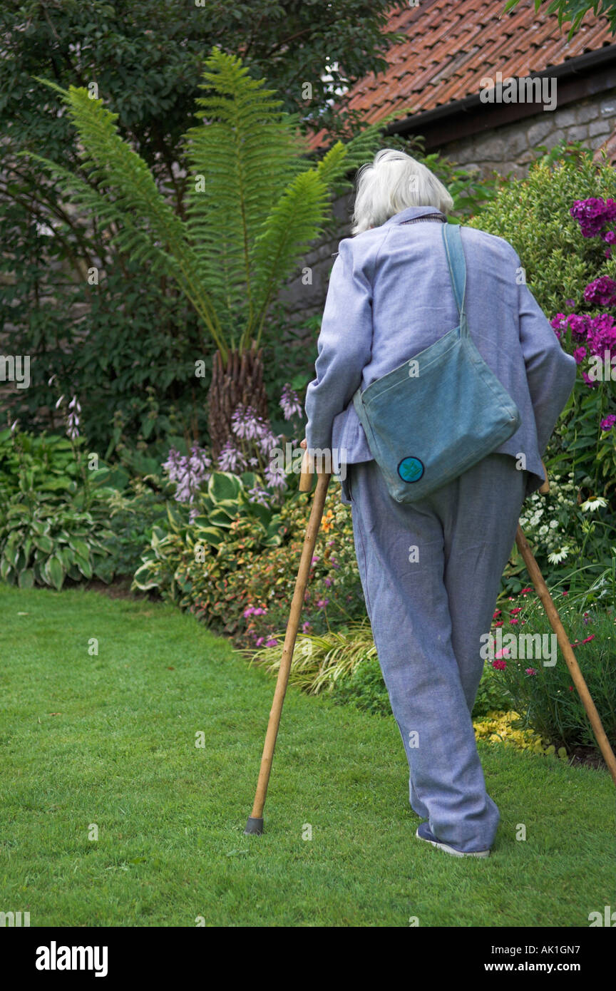 Älteren Erwachsenen gehen mit Stöcken im Garten Stockfoto