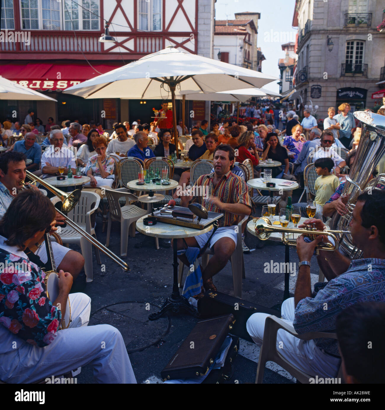 Lebendige französischen Café-Szene mit lokalen jazz-Band unterhalten an Bar im Freien, während Menschen mit Getränken in St-Jean-de-Luz-France sitzen Stockfoto