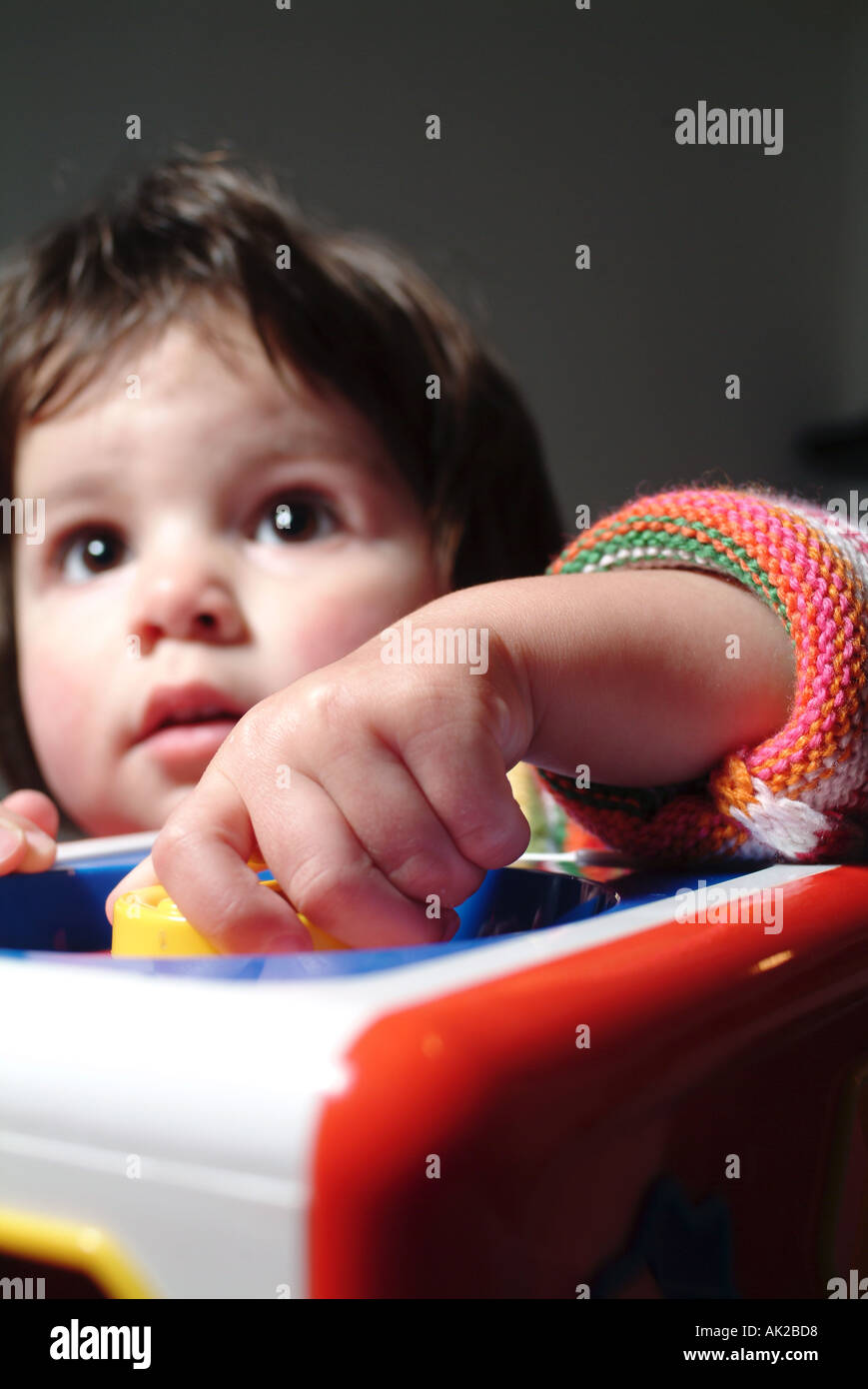 kleine Mädchen zwei Jahre alt spielt mit Spielzeug in einem Kinderzimmer Stockfoto