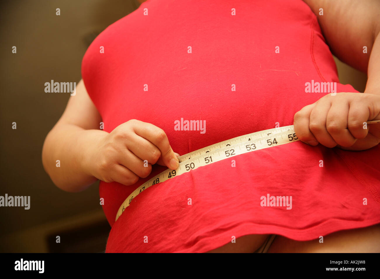 übergewichtige Frau, die ihre Taille messen Stockfoto