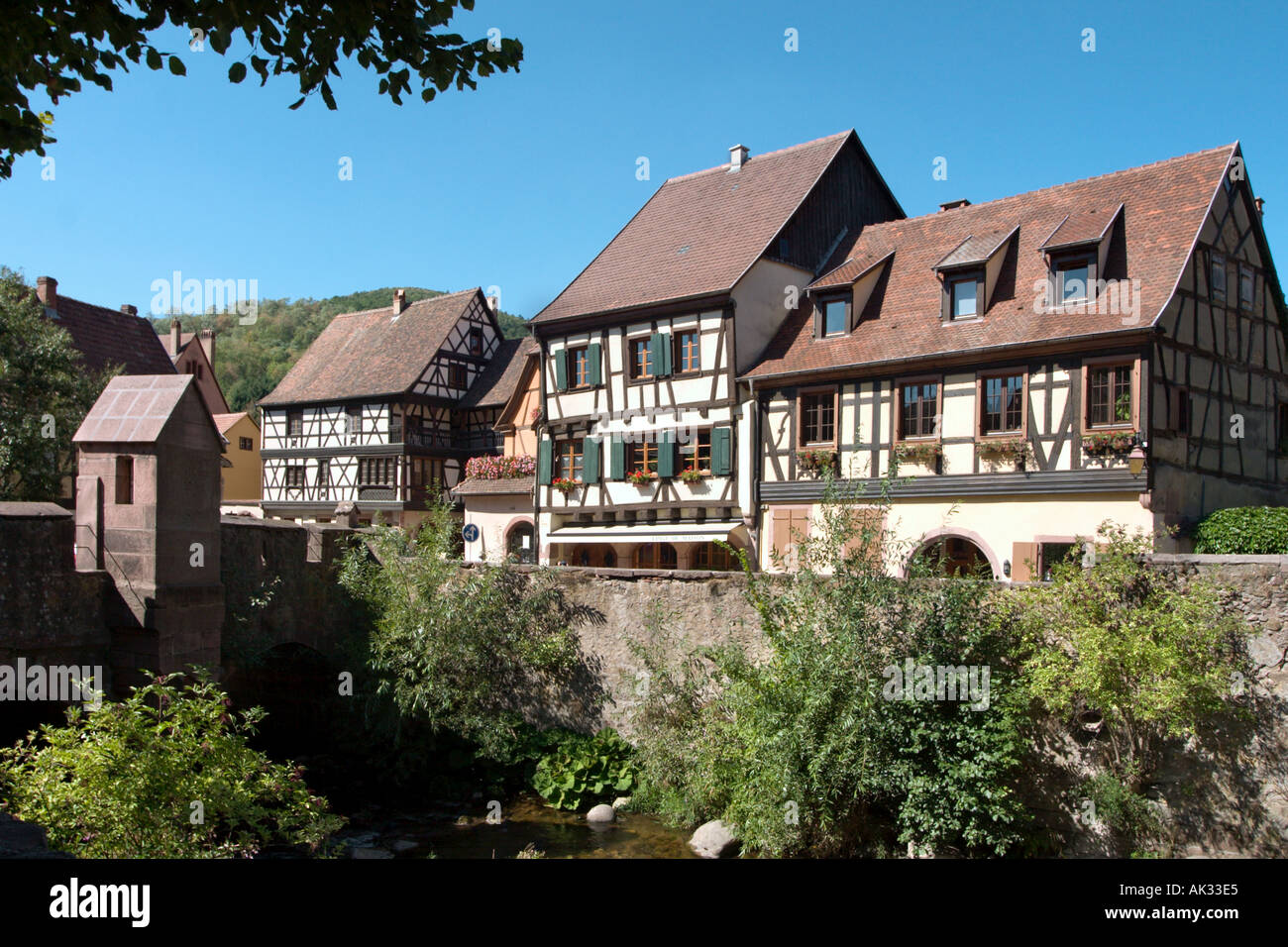 Traditionelle Häuser durch die befestigte Brücke, Kayserberg, Elsass, Frankreich Stockfoto