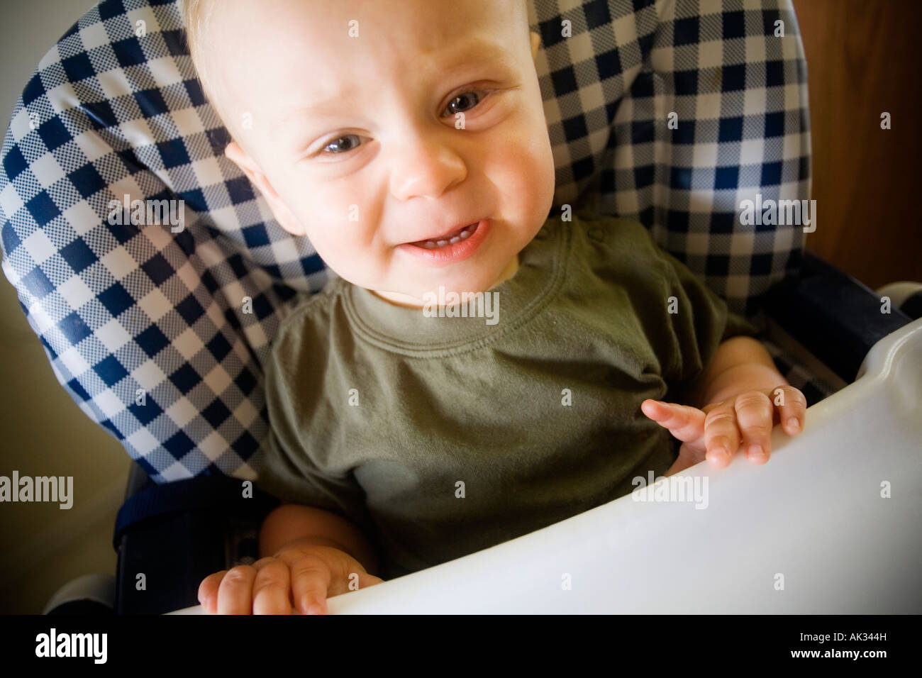 Babyjungen Weinen im Hochstuhl Stockfoto