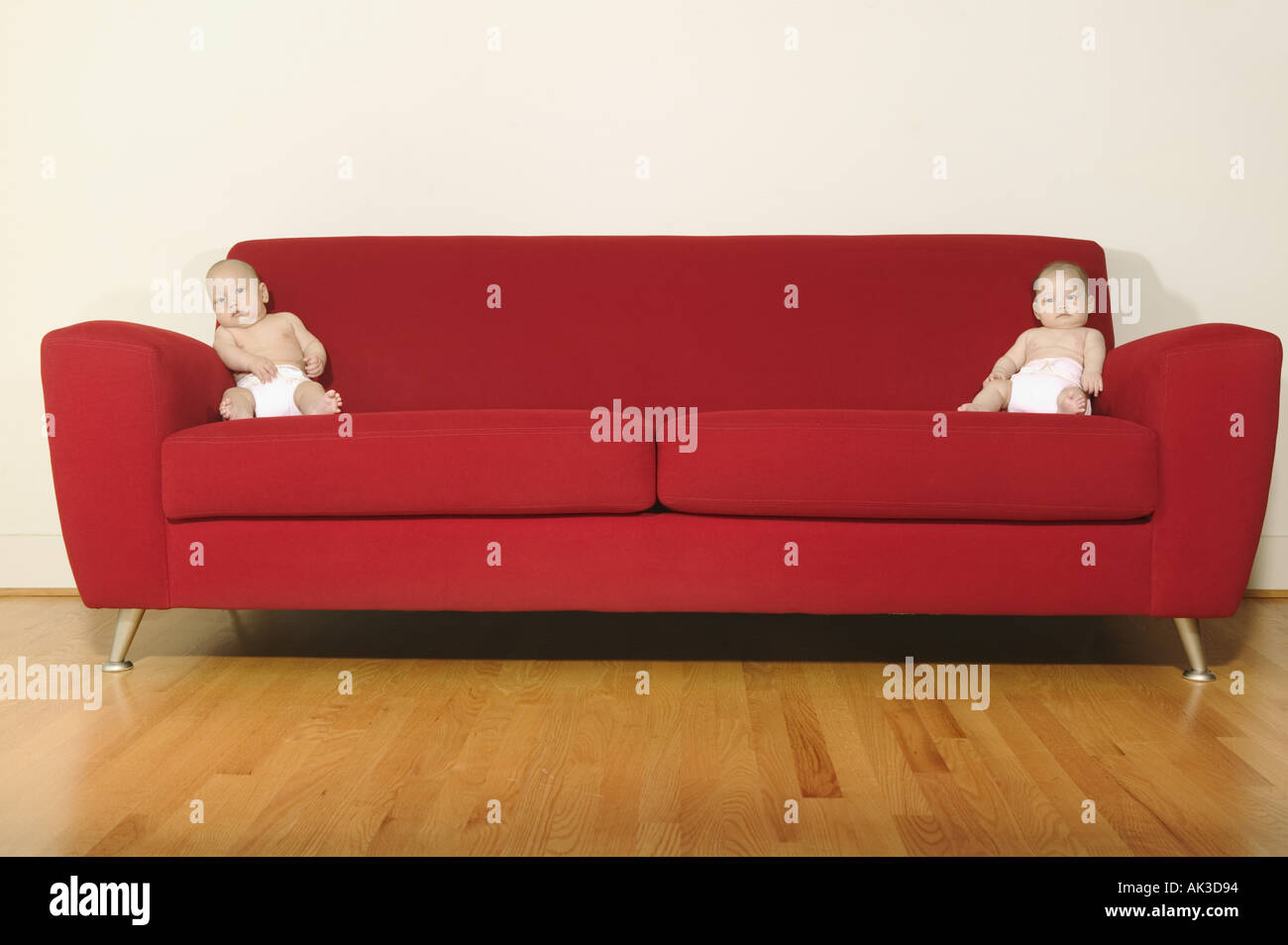 Zwillingen an jedem Ende ein rotes sofa Stockfoto