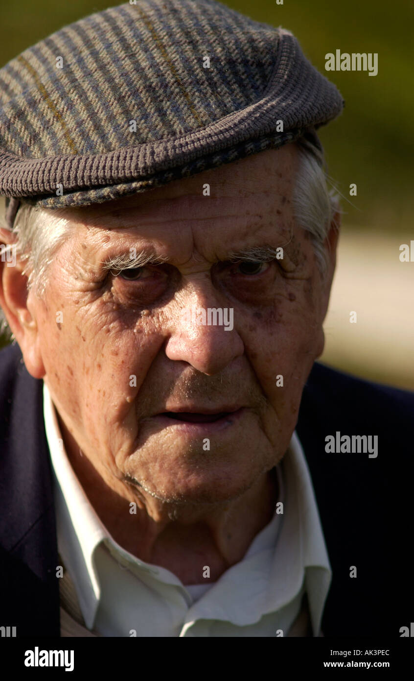 Porträt von mürrisch aussehende Rentner in eine flache Kappe Stockfoto