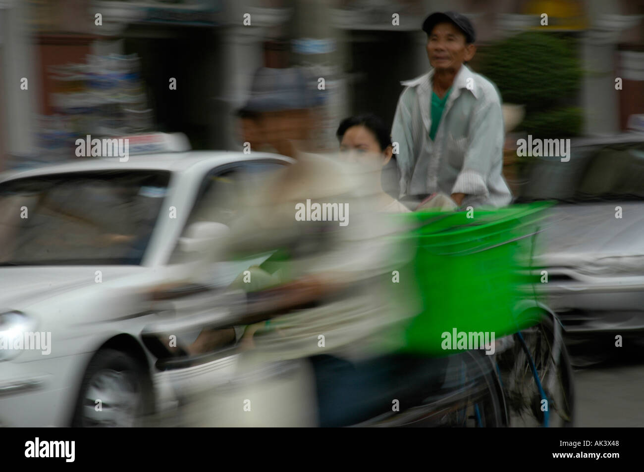 Bewegungsunschärfe Cyclofahrer Im dreckigem Verkehr Ho Chi Minh Stadt Saigon Vietnam verschwommen Bewegung Cyclo-Fahrer unter schweren Stockfoto