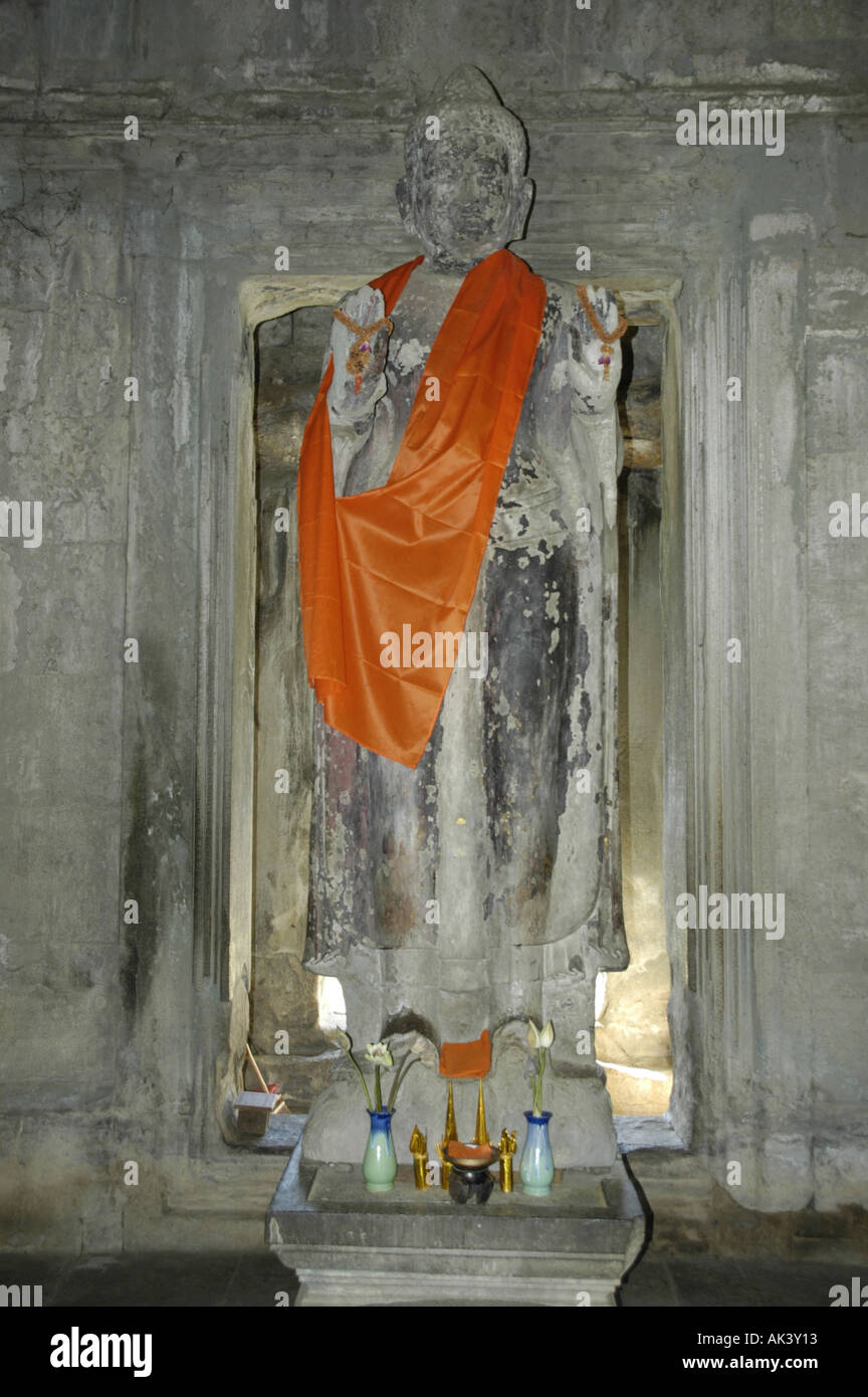 Statue eines stehenden Buddha trägt einen orange Kap Tempel Angkor Wat Siem Reap Kambodscha Stockfoto