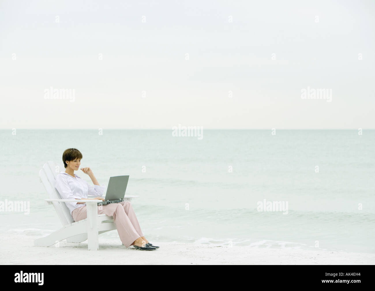 Frau mit Laptop am Strand Stockfoto