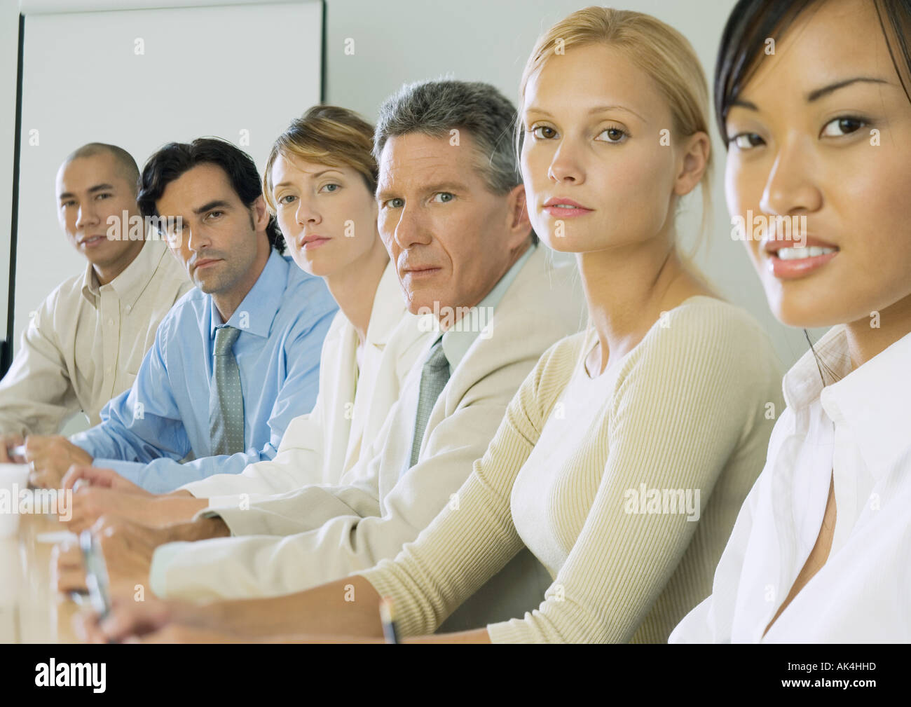 Reihe von Geschäftsleuten, die am Tisch sitzen Stockfoto