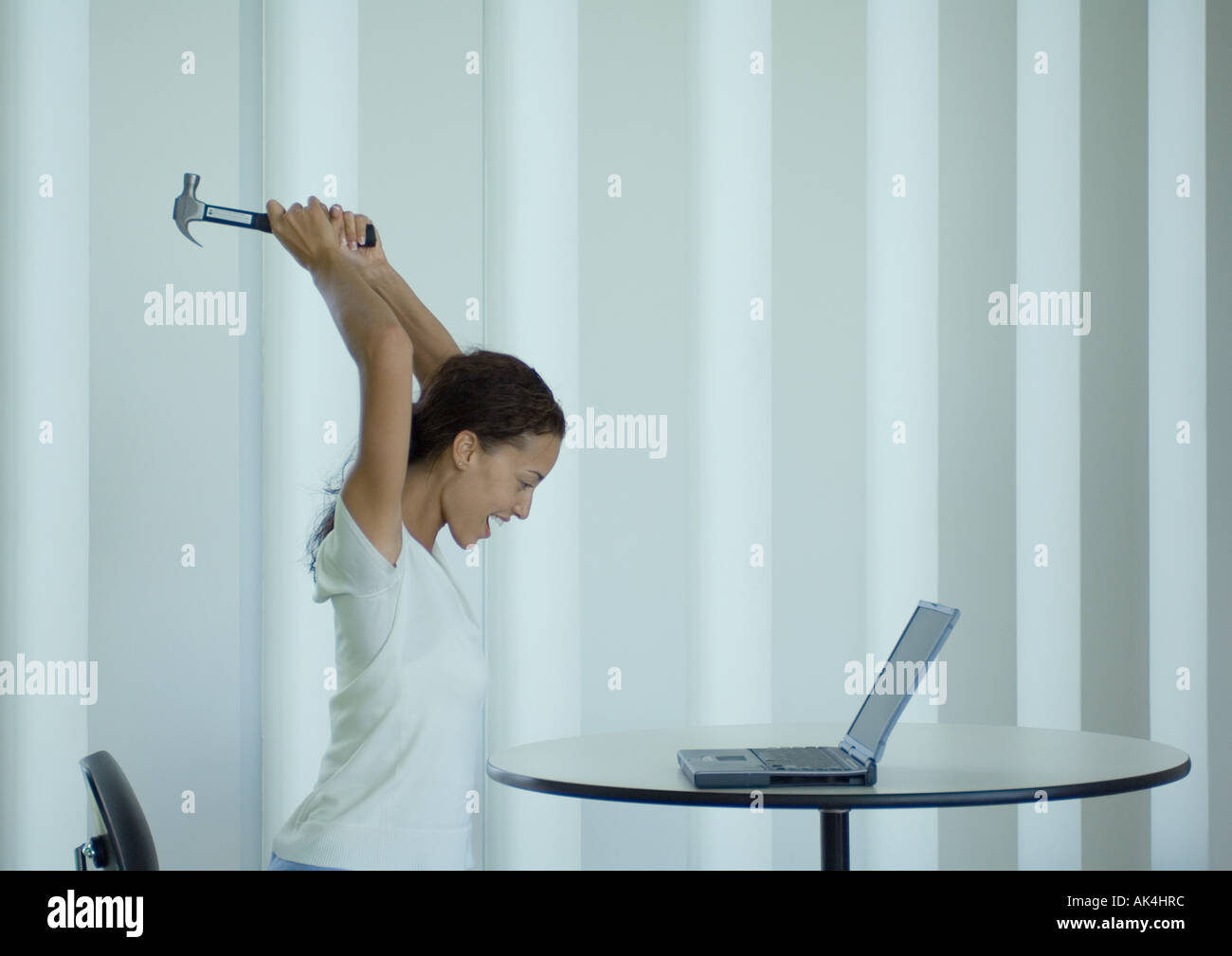 Frau schreien und schwingen Hammer am laptop Stockfoto