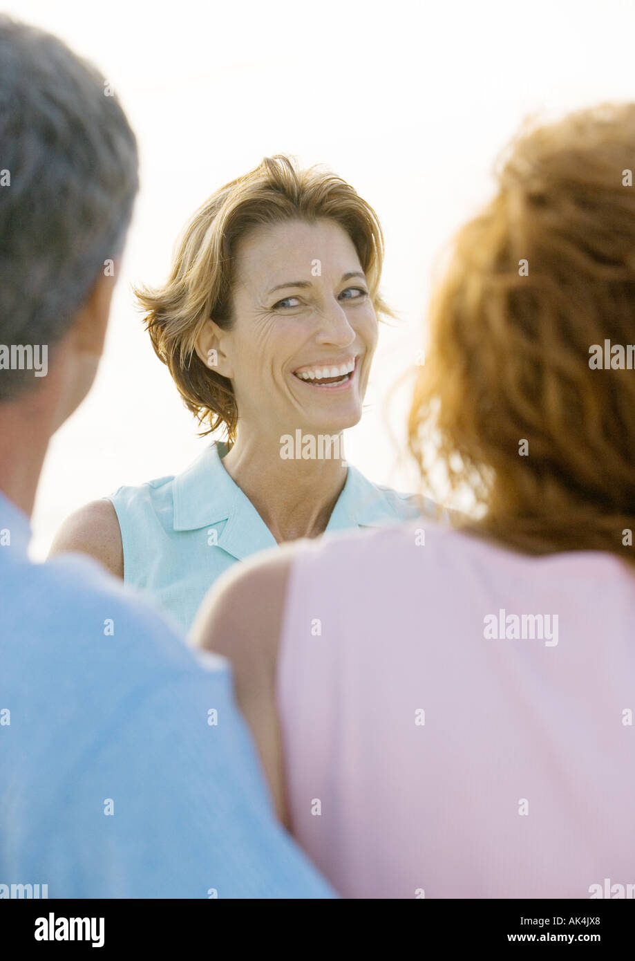 Reife Frau lächelnd an Freunde Stockfoto