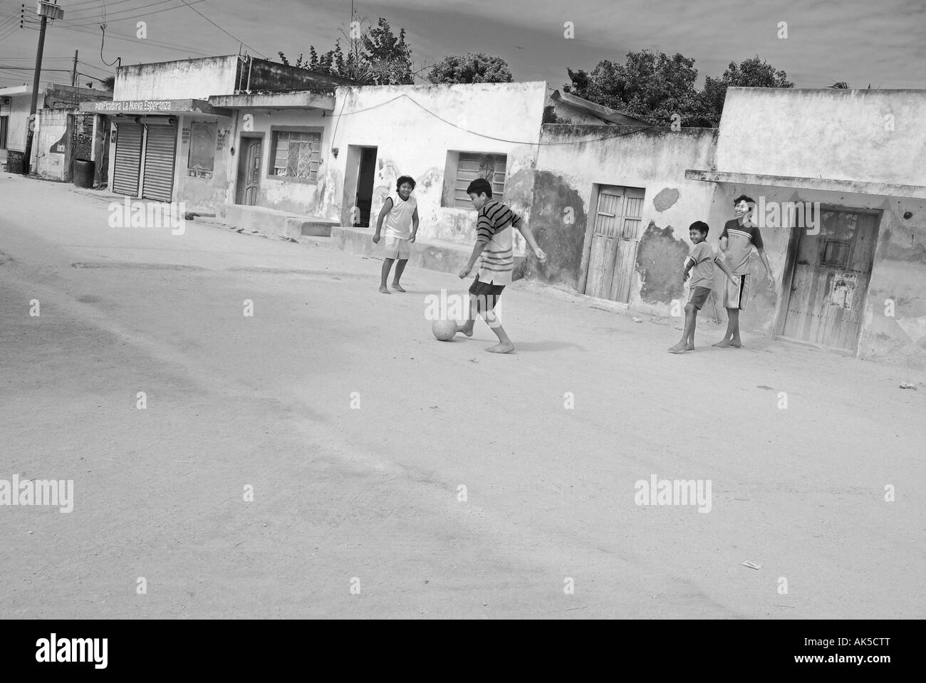 Jungen Fußball spielen auf der Straße von Celestun Willage Yucatan Mexiko Stockfoto