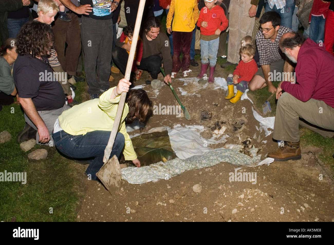 Eröffnung der Grube Ofen bei einem Curanto heißen Kochen in einer Grube Ofen Gemüse und Fleisch kochen auf Steinen Stockfoto