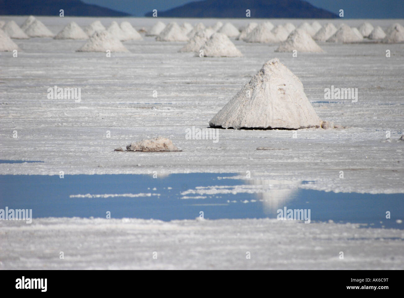 Salz Hügel werden von den Einheimischen zum Trocknen auf den Salar de Uyuni in der Nähe von Uyuni, Bolivien, Südamerika gestapelt. Stockfoto
