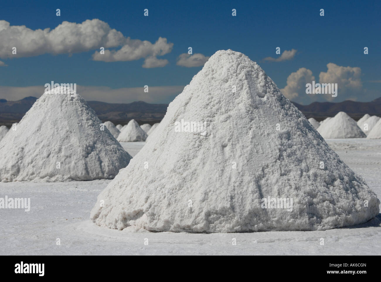 Salz Hügel werden von den Einheimischen zum Trocknen auf den Salar de Uyuni in der Nähe von Uyuni, Bolivien, Südamerika gestapelt. Stockfoto