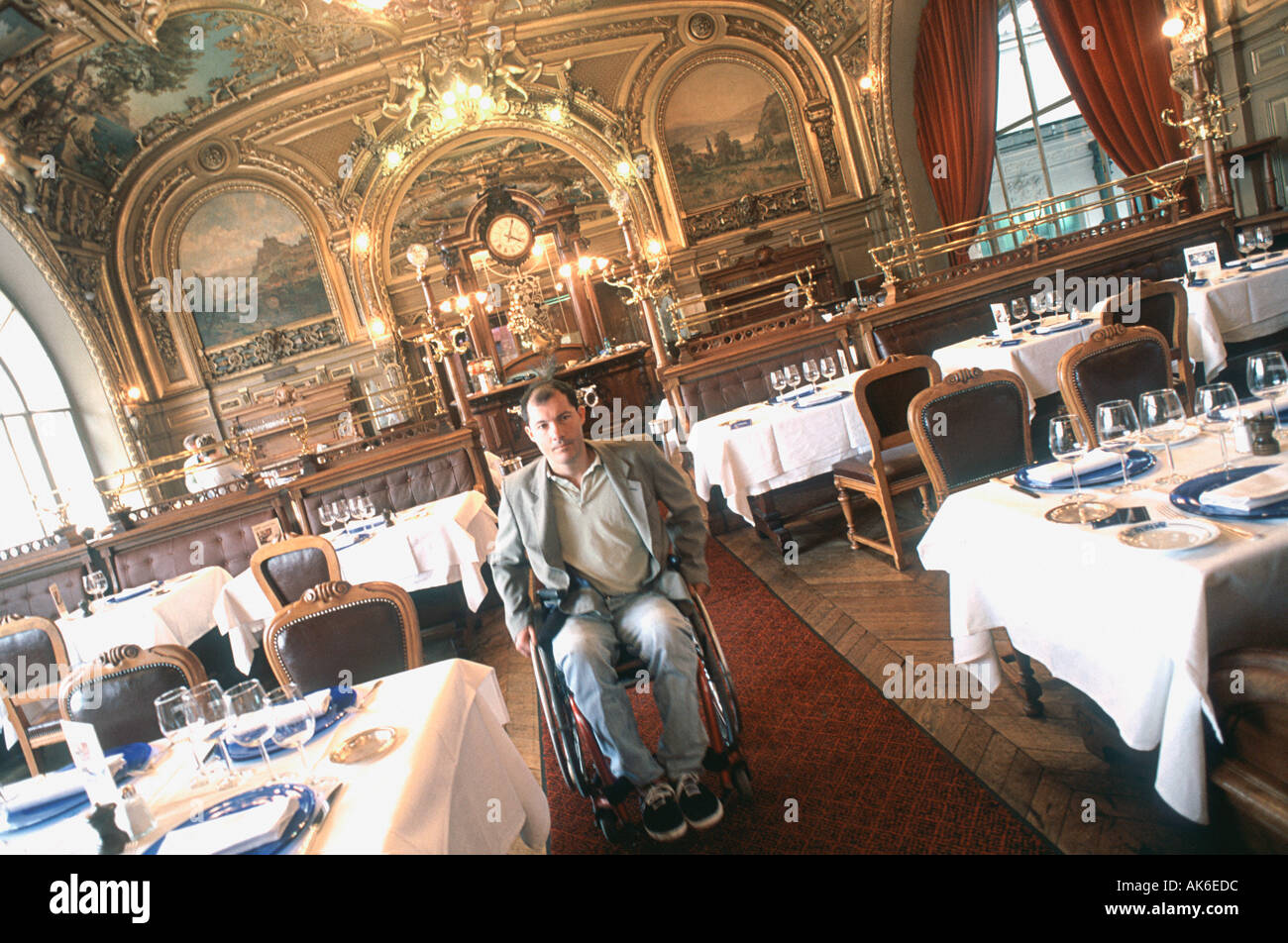 Behinderter Mann im Urlaub in 'Französisch Restaurant' 'Le Train Bleu' im Rollstuhl Paris Frankreich, alte Brasserie, Zugang für besondere Bedürfnisse Stockfoto