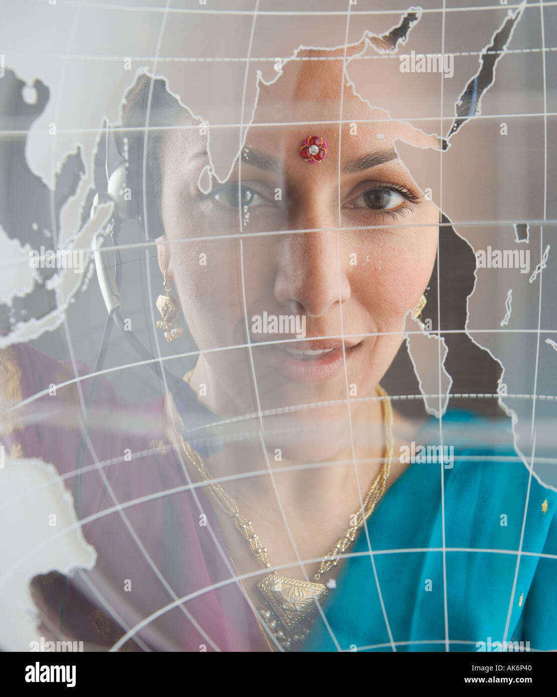 Frau in traditioneller indischer Kleidung hinter Globus Stockfoto