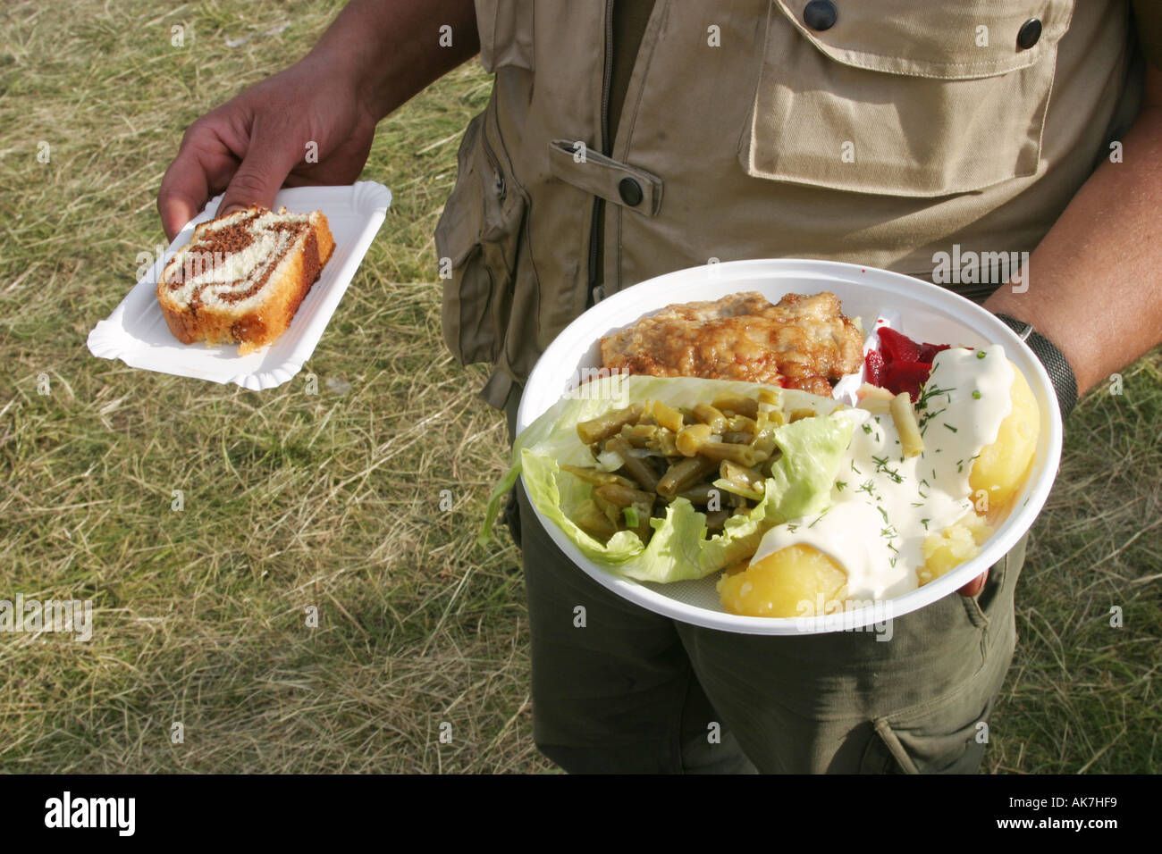 Essen auf einem Plastikteller und Kuchen auf Karton Stockfoto