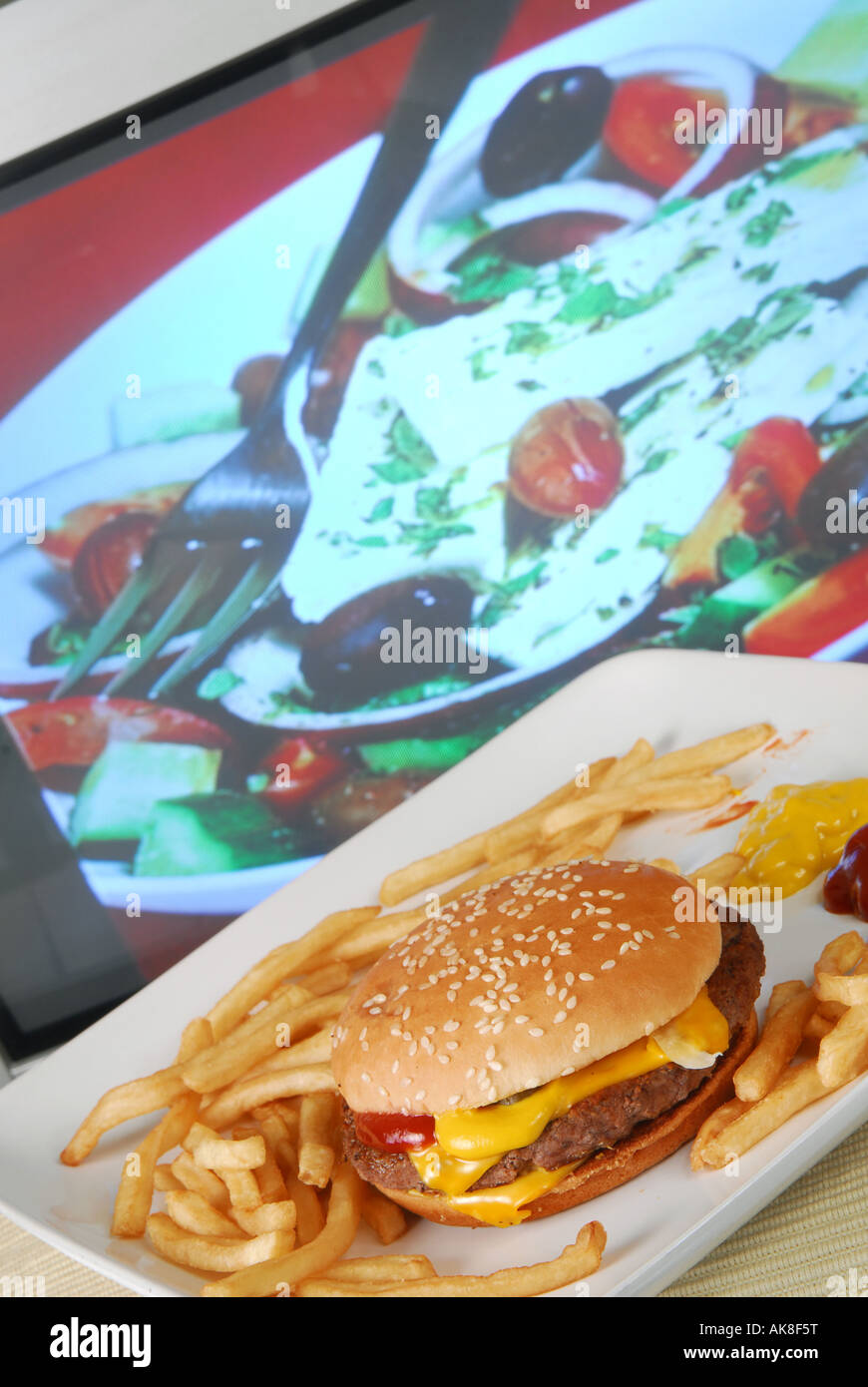 Konzept zu ungesunden Fastfood TV Dinner vor Kochen Fernsehprogramm zeigt gesunde griechischen Salat zeigen erschossen Stockfoto