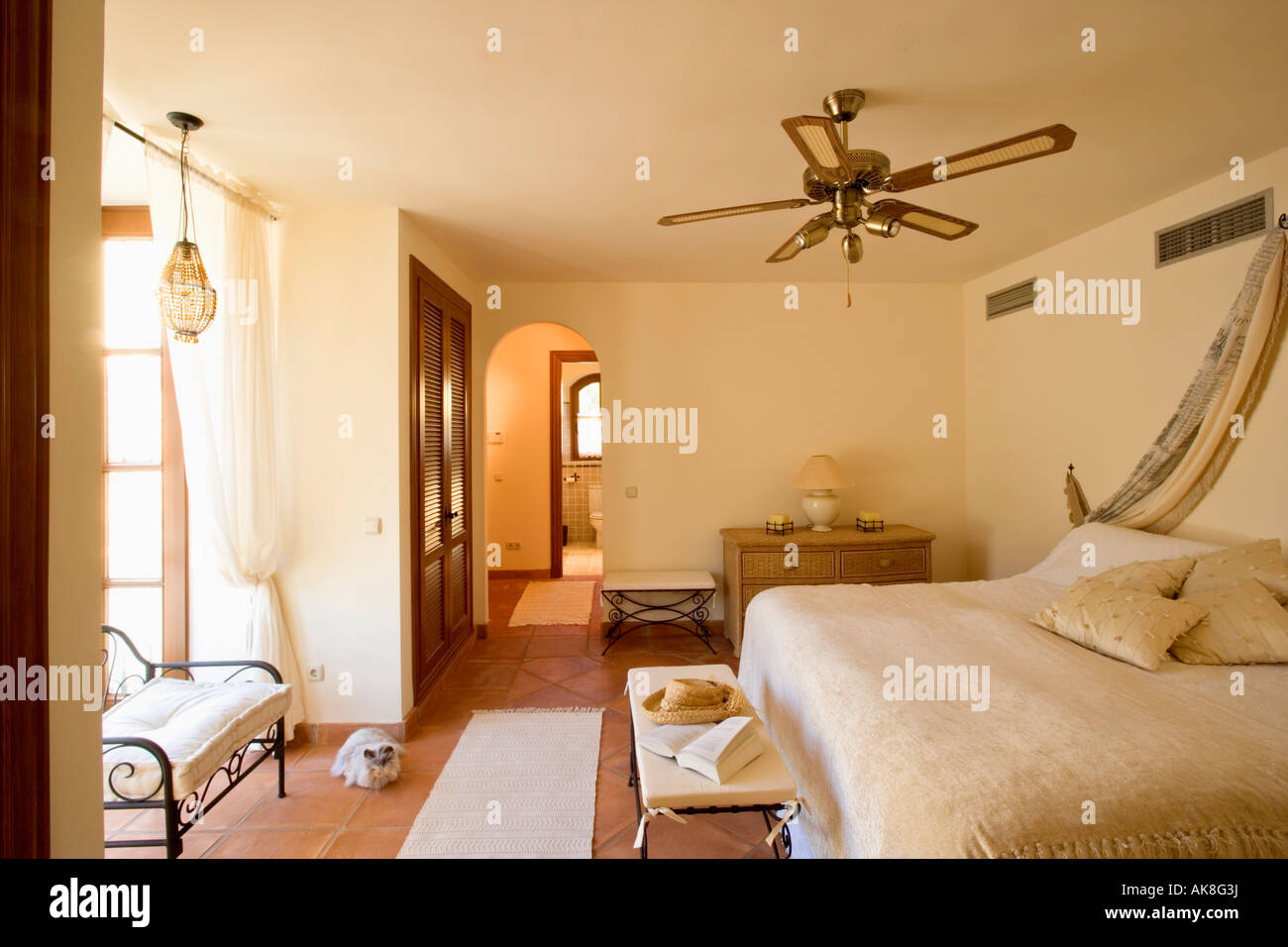 Deckenventilator über dem Bett mit Creme Bettdecke im Schlafzimmer in  Spanisches Appartement Stockfotografie - Alamy
