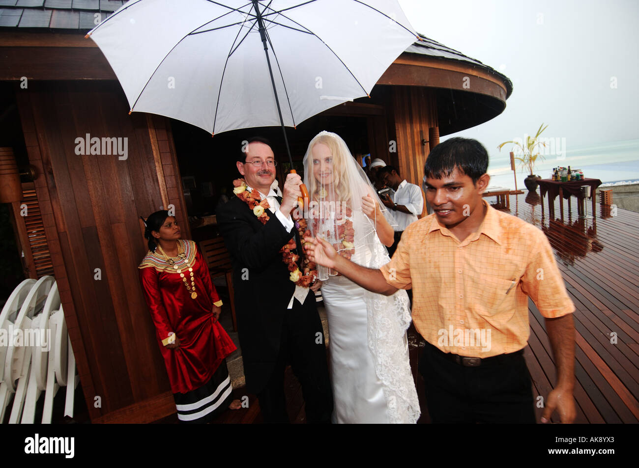 Olhuveli Resort Adrian Godwin aus England und Elvira Andreeva aus dem russischen laufen vor dem Regen während einer mock Hochzeitszeremonie Stockfoto