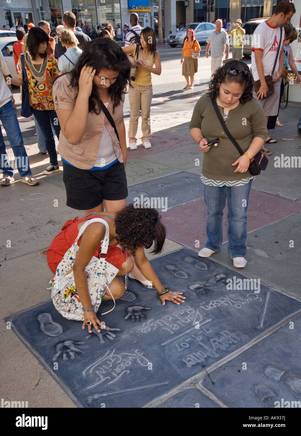 Urlauber, die bei der hand und Fußabdrücke von Akteuren aus den Harry Potter Filmen am Chinese Theatre in Hollywood, Kalifornien, USA Stockfoto