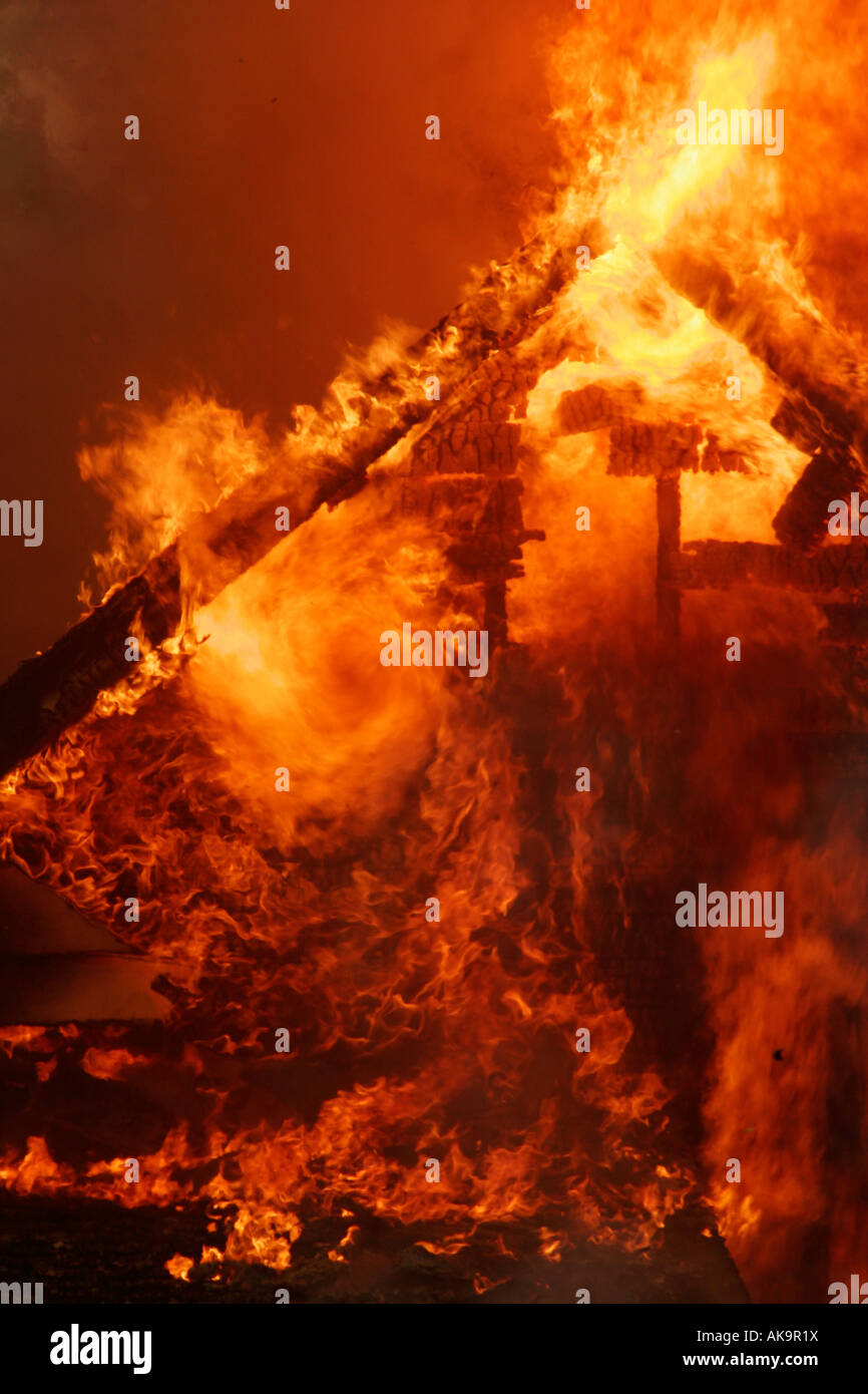 Flammen, die Rollen eines Tornados unter die Dachlinie eines Struktur-Brandes Stockfoto