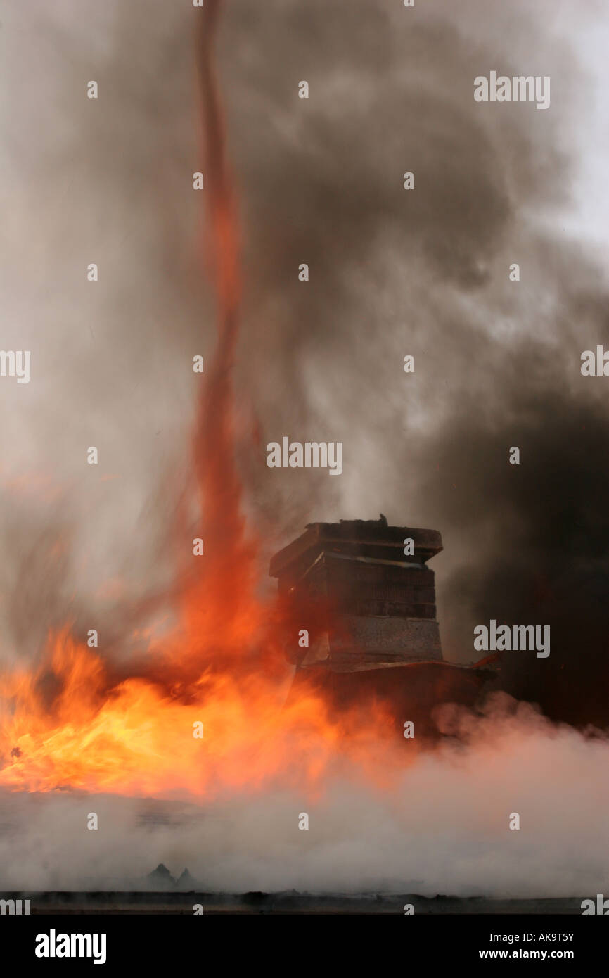 Flammen bilden einen Tornado von Hitze und Rauch aus dem Dach des einen Hausbrand Stockfoto