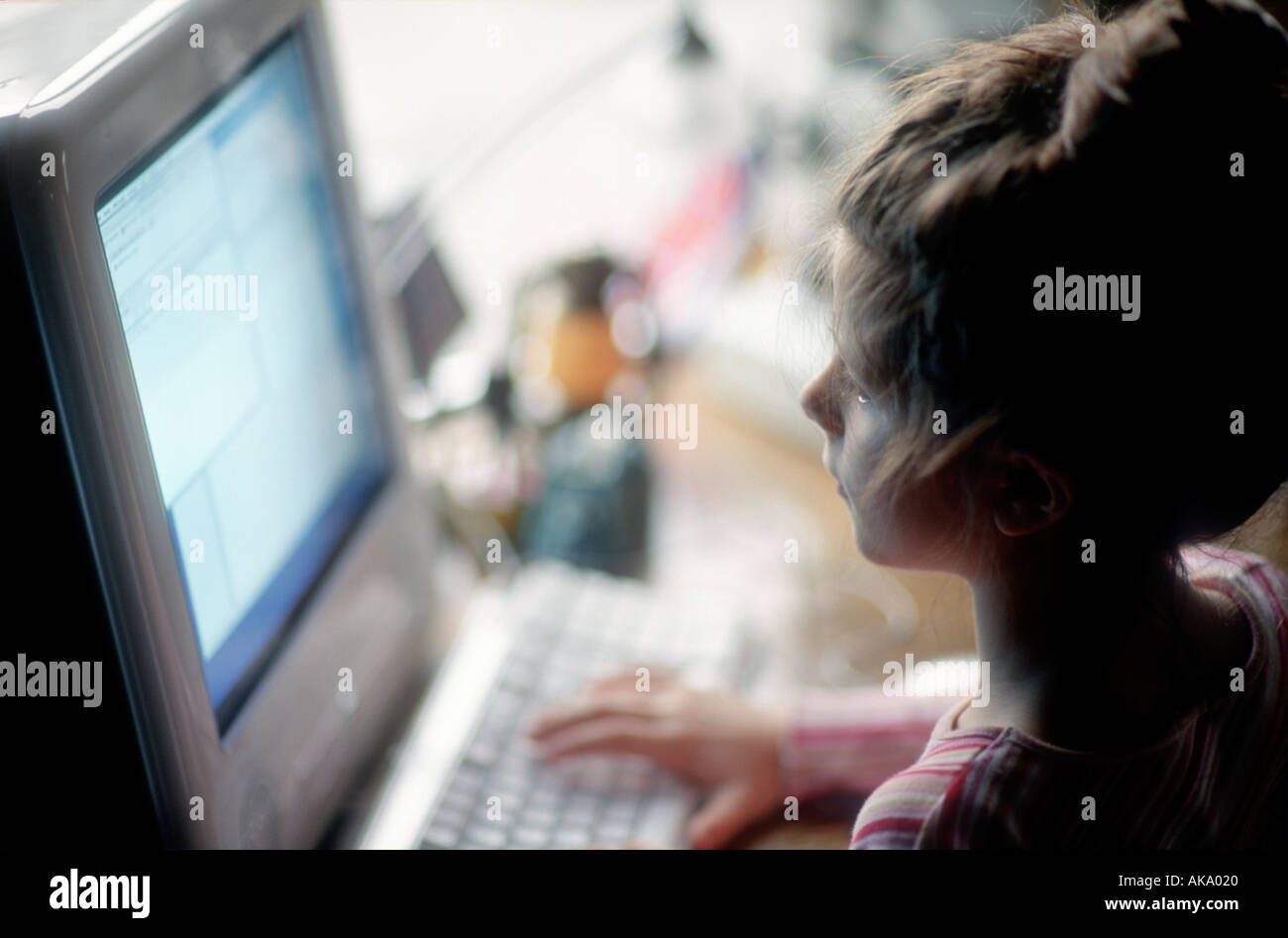 acht Jahre altes Mädchen mit Blick auf desktop Stockfoto