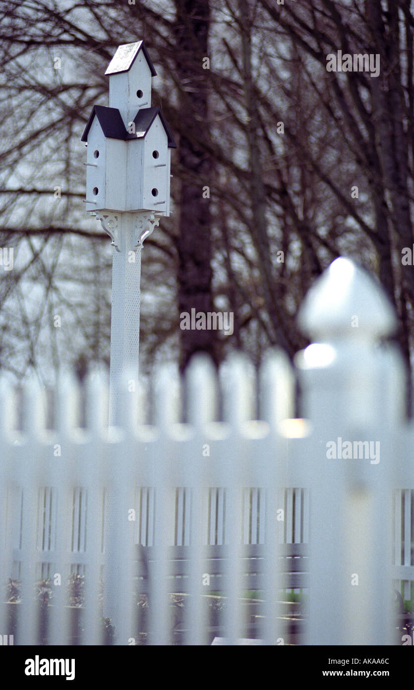 Mehrstufige Vogelhaus mit weißen Lattenzaun im Vordergrund Stockfoto