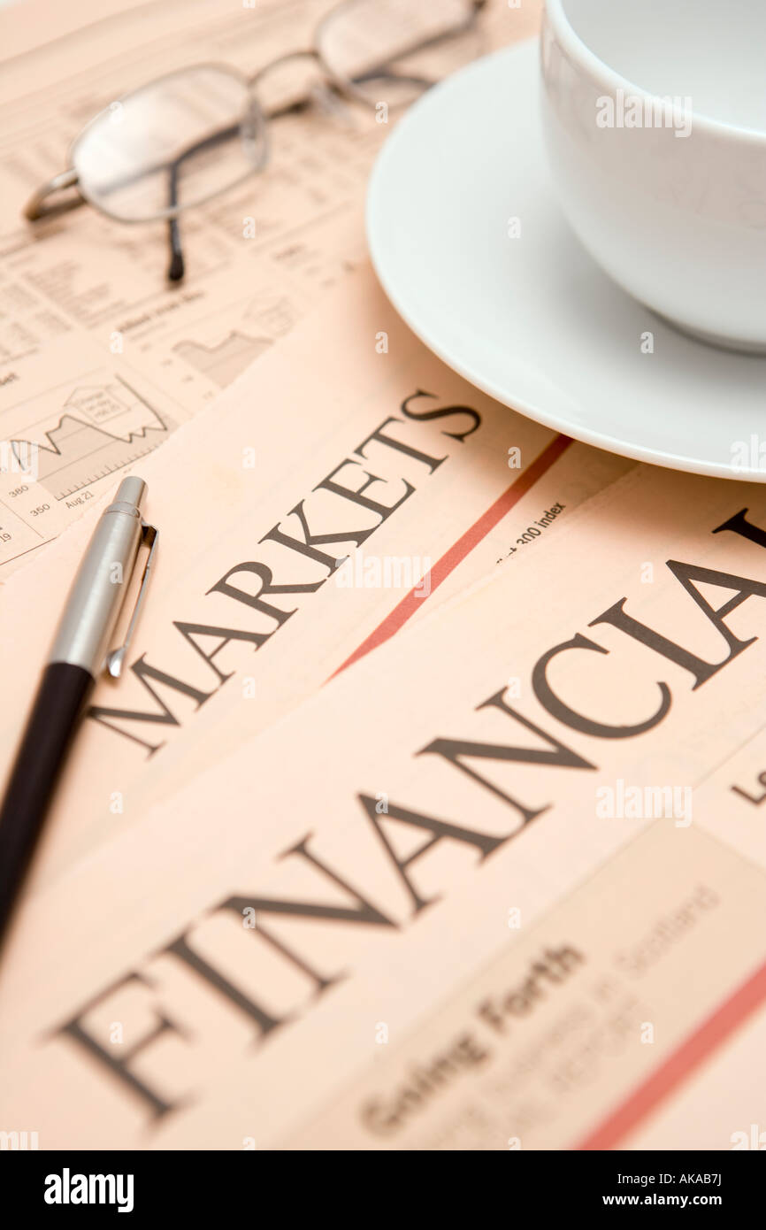 Finanzzeitung Studium Aktien und Aktien und Finanzmärkte für möglichen Gewinner mit einer Tasse Tee Stift und Brille Stockfoto