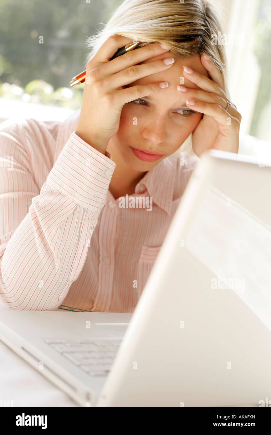 Frau, die gestresst am Laptop Stockfoto