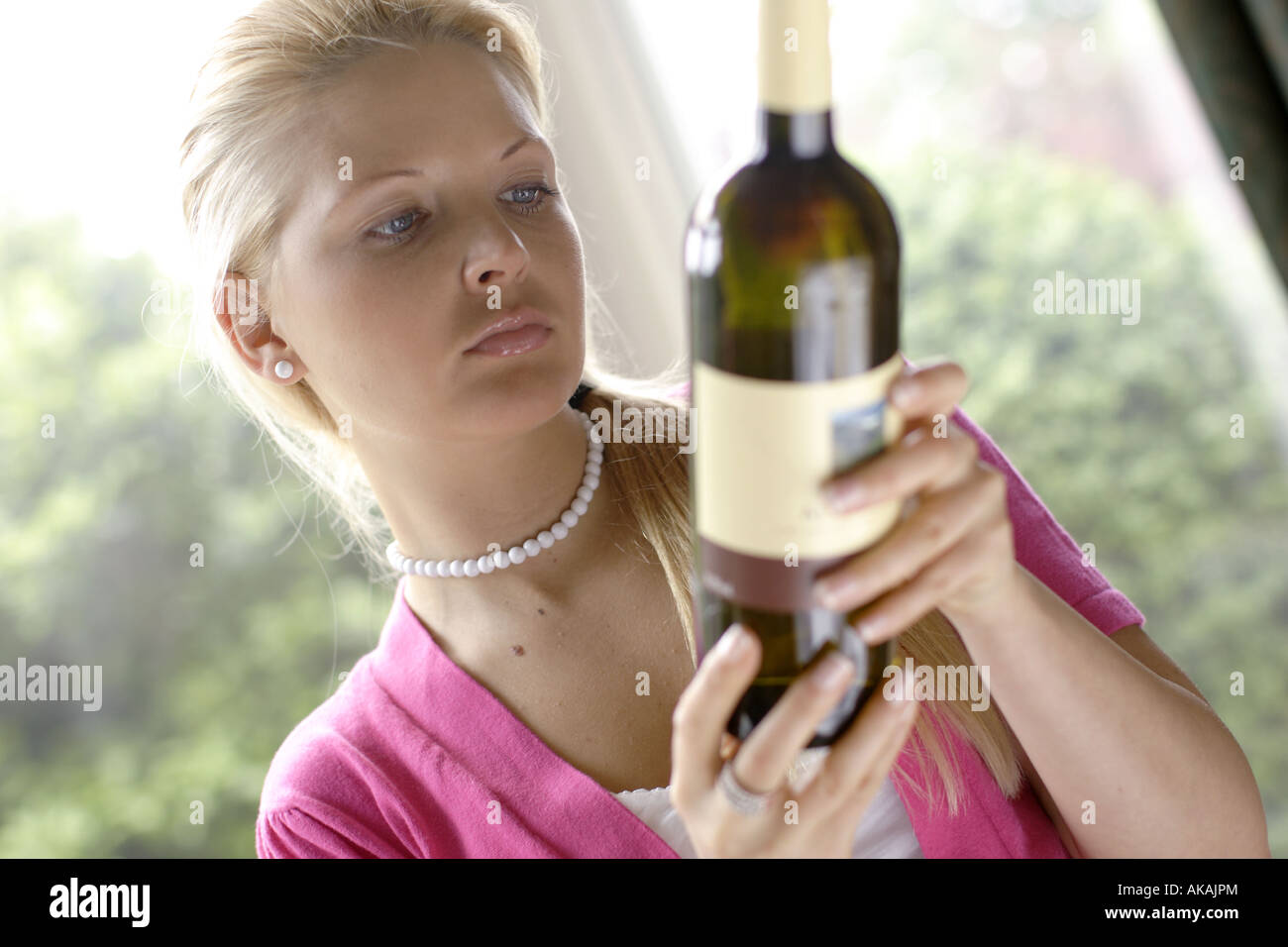 Frau betrachten Aufkleber auf Weinflasche Stockfoto