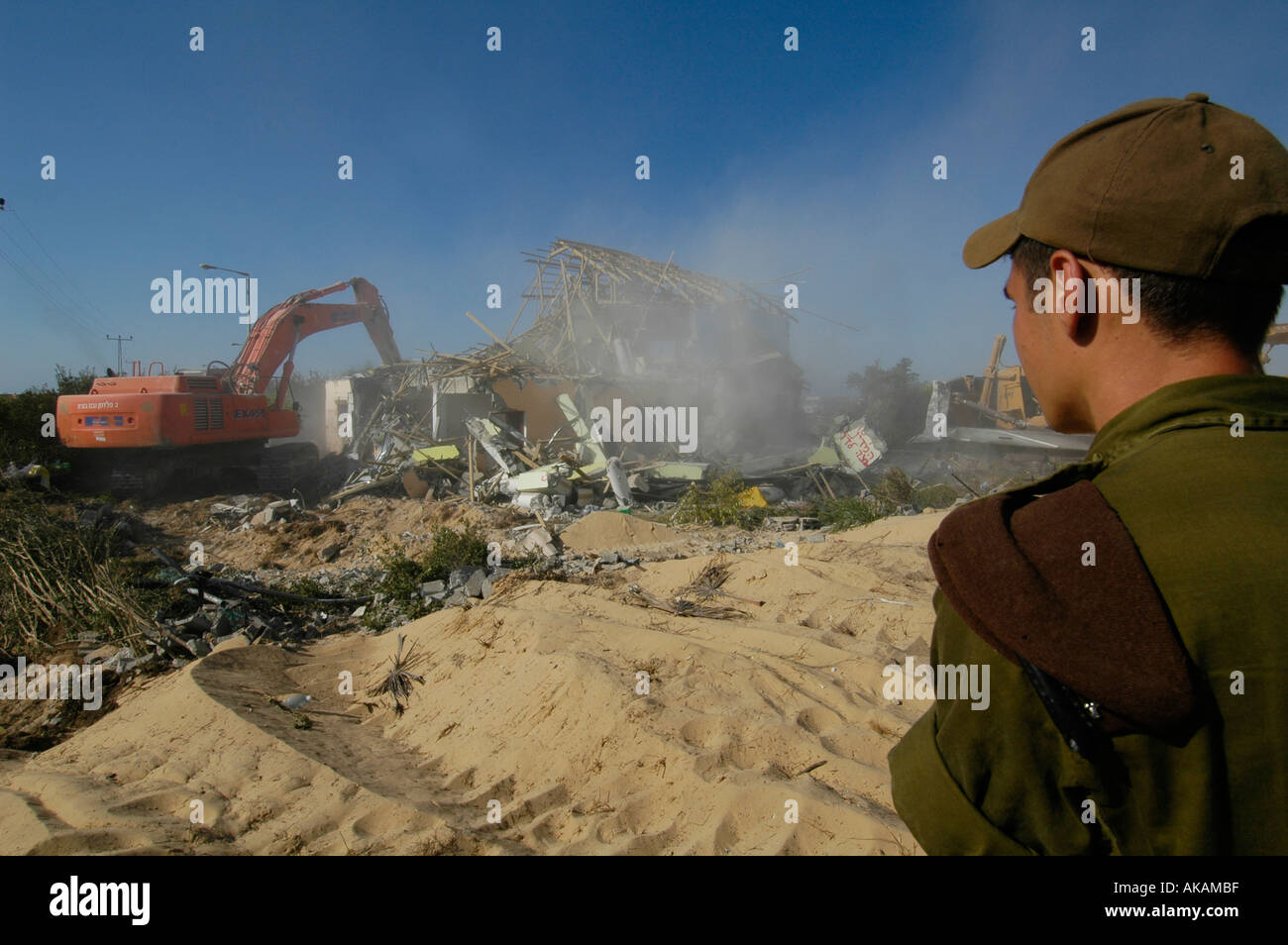 Israelischer Soldat Watch eine Planierraupe demolieren verlassene Häuser jüdischer Siedler in der Abwicklung von Netzer hazani in Gaza Strip zu sein Stockfoto