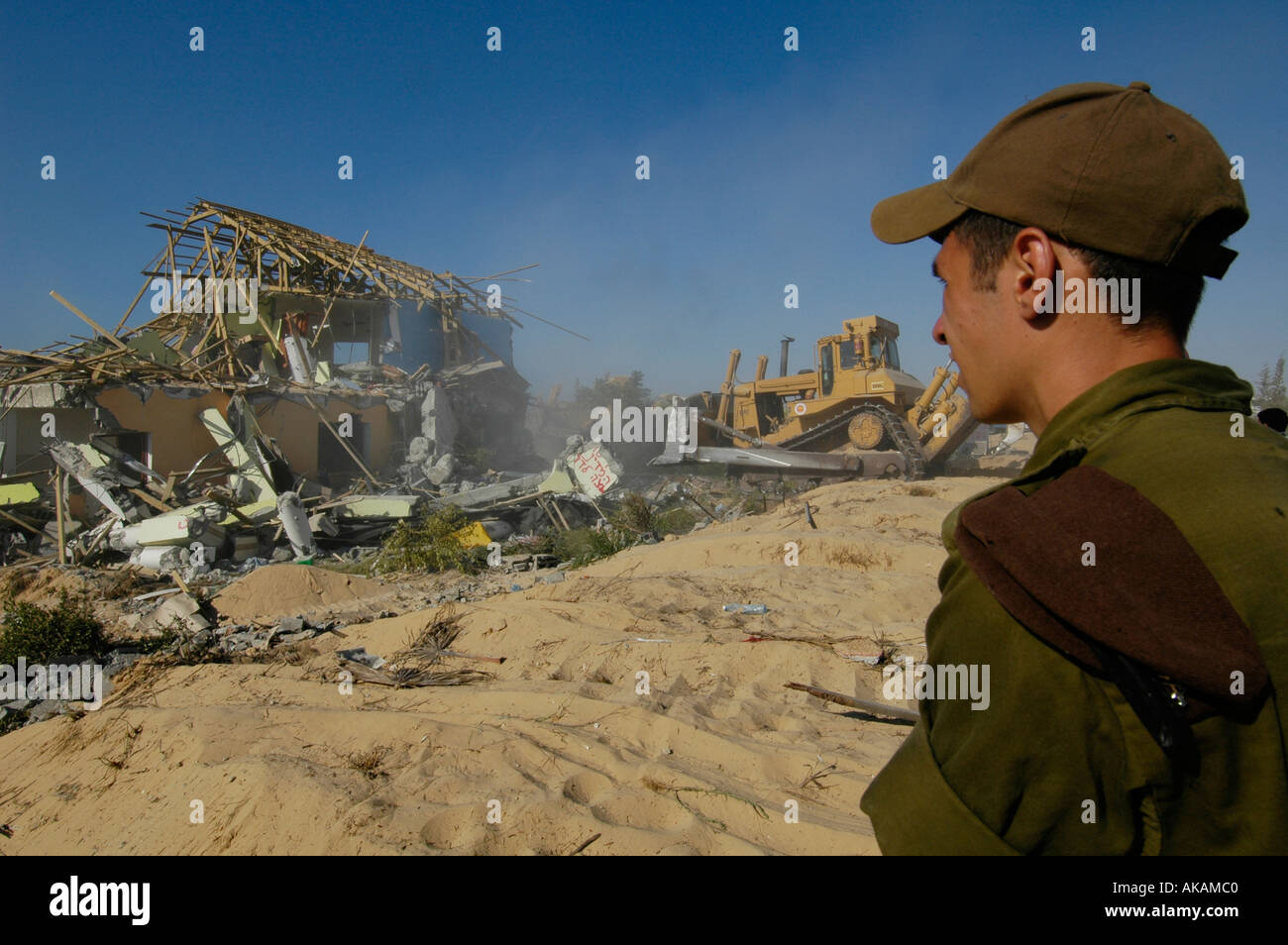 Israelischer Soldat Watch eine Planierraupe demolieren verlassene Häuser jüdischer Siedler in der Abwicklung von Netzer hazani in Gaza Strip zu sein Stockfoto
